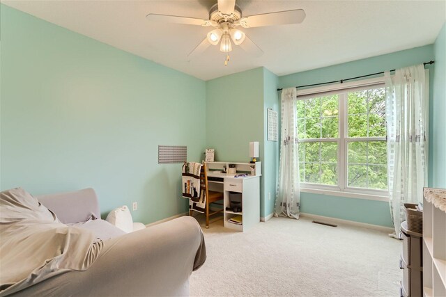 carpeted home office featuring plenty of natural light and ceiling fan