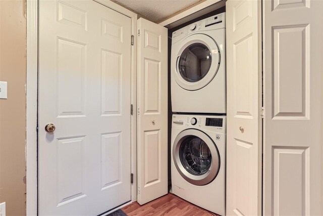 washroom featuring stacked washer and clothes dryer and hardwood / wood-style floors