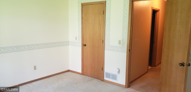 hallway featuring light colored carpet