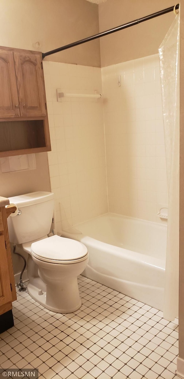 bathroom featuring tile patterned flooring, shower / bath combo, and toilet