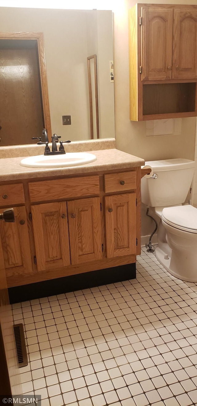 bathroom with vanity, tile patterned floors, and toilet