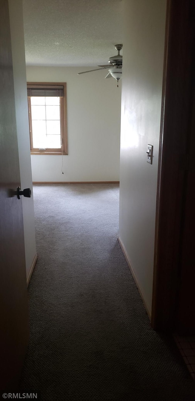 empty room featuring light carpet, a textured ceiling, and ceiling fan