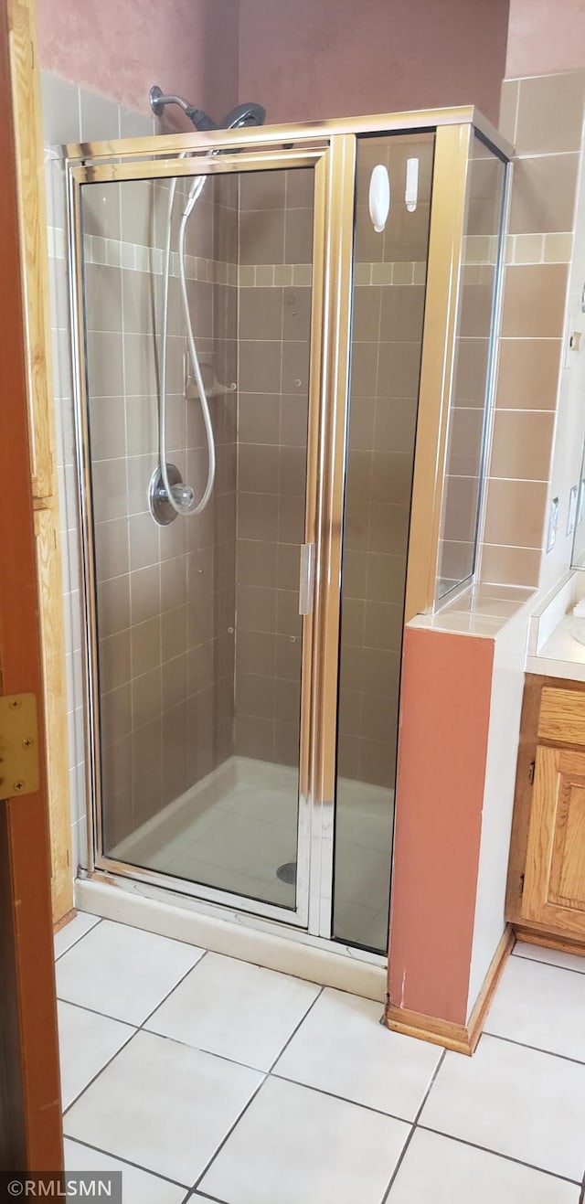 bathroom featuring vanity, a shower with door, and tile patterned floors