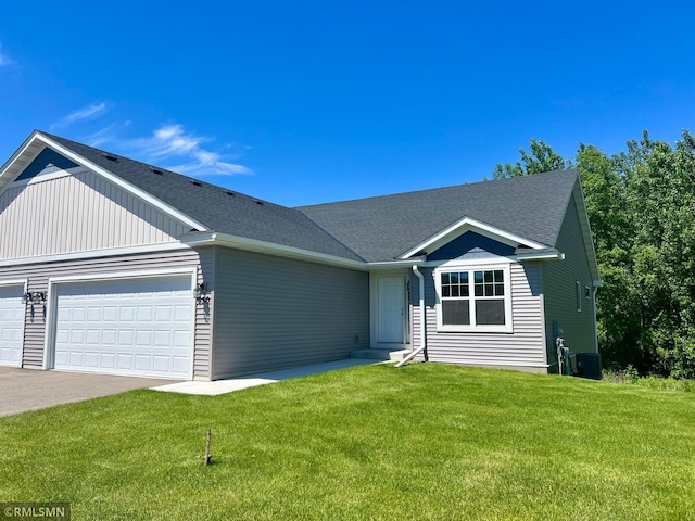 view of front facade featuring cooling unit, a garage, and a front lawn