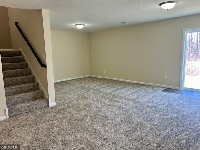 carpeted spare room with a textured ceiling