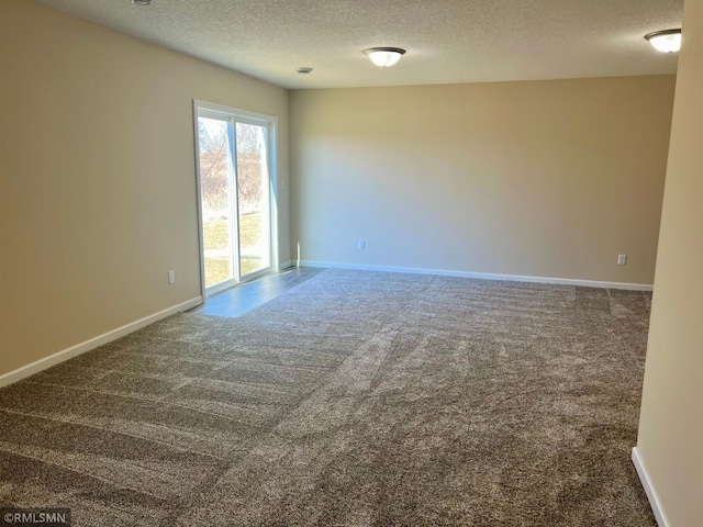 carpeted spare room with a textured ceiling