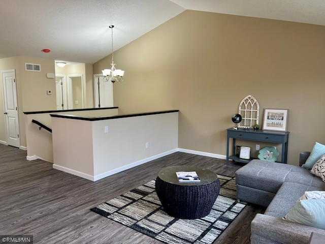 living room featuring a chandelier, dark wood-type flooring, and vaulted ceiling