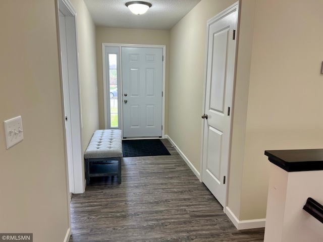 doorway to outside featuring a textured ceiling and dark hardwood / wood-style flooring