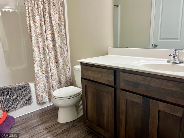 full bathroom featuring hardwood / wood-style floors, vanity, toilet, and shower / bath combo with shower curtain