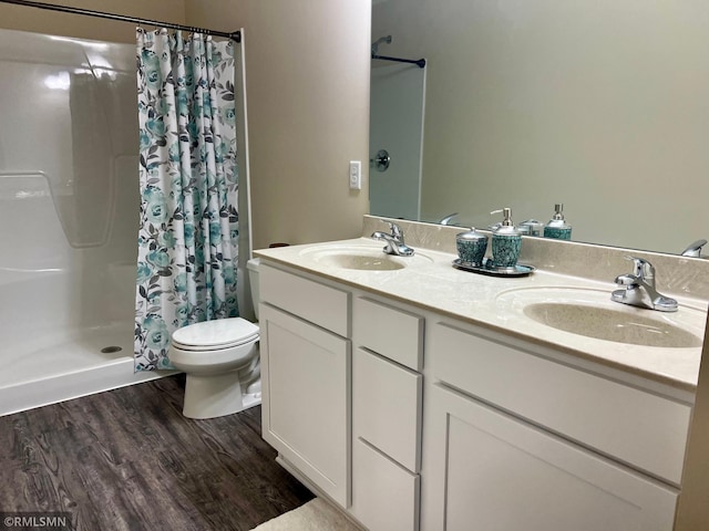 bathroom featuring toilet, hardwood / wood-style floors, vanity, and walk in shower