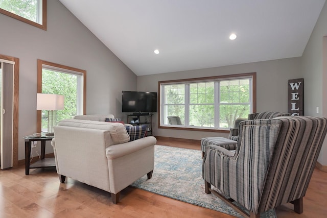 living room featuring vaulted ceiling, light hardwood / wood-style floors, and plenty of natural light