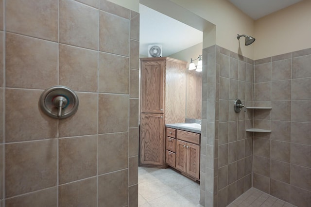 bathroom featuring tile patterned floors, tiled shower, and vanity