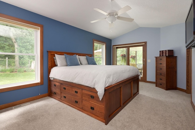 bedroom with multiple windows, light carpet, access to exterior, vaulted ceiling, and ceiling fan