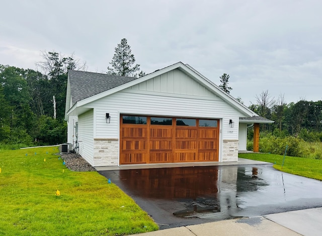 exterior space with a front yard, a garage, and central AC