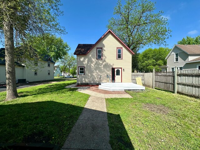 back of property featuring a yard and central AC