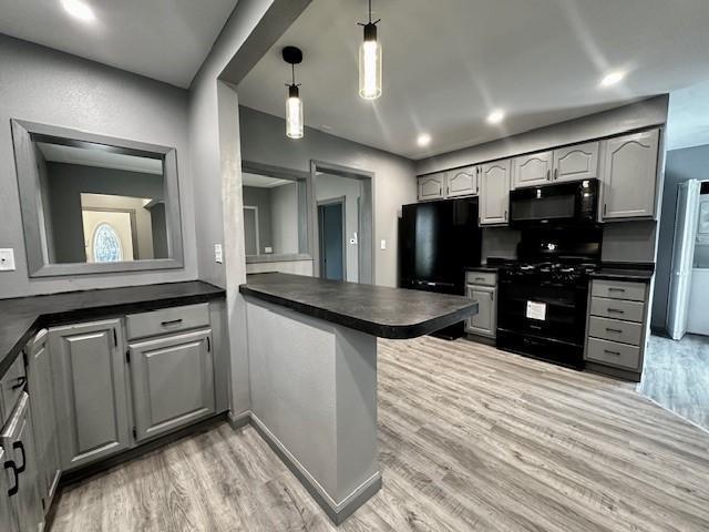 kitchen featuring gray cabinets, hanging light fixtures, black appliances, and kitchen peninsula