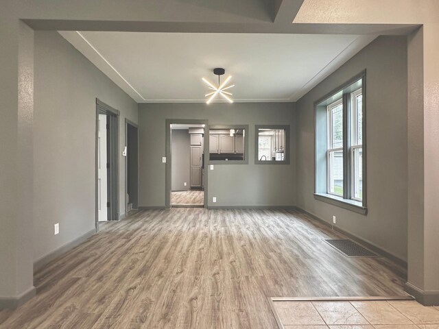 unfurnished living room with hardwood / wood-style floors and a notable chandelier