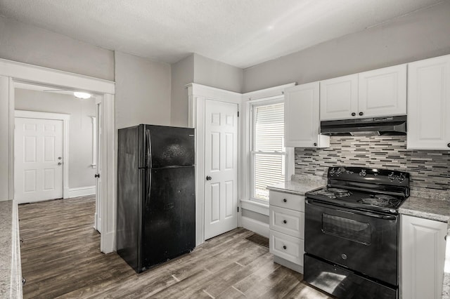 2806 Aldrich Ave N, Minneapolis, MN 55411 - kitchen featuring black appliances, under cabinet range hood, wood finished floors, white cabinets, and backsplash