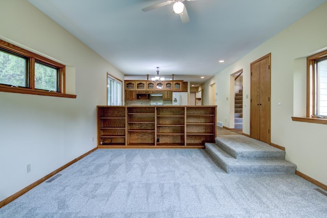 interior space with light carpet, a healthy amount of sunlight, and ceiling fan