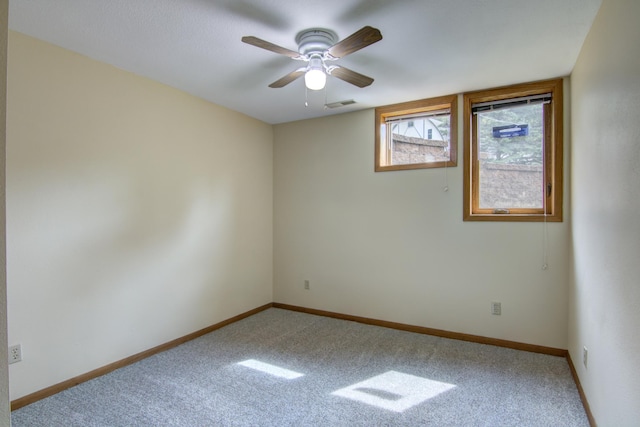 carpeted spare room featuring ceiling fan