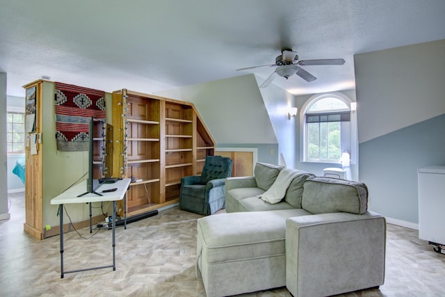 living room with a textured ceiling and ceiling fan