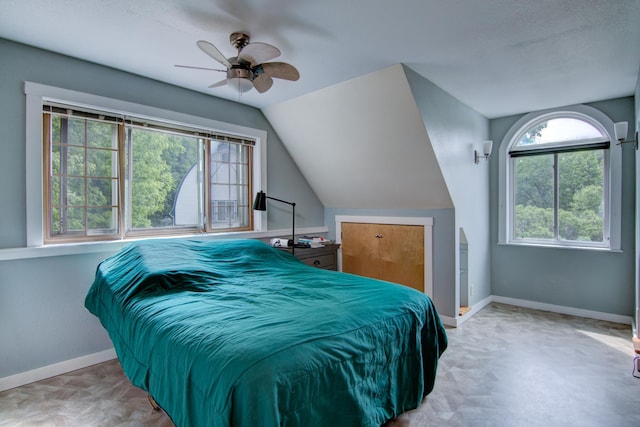 bedroom featuring lofted ceiling, a textured ceiling, and ceiling fan