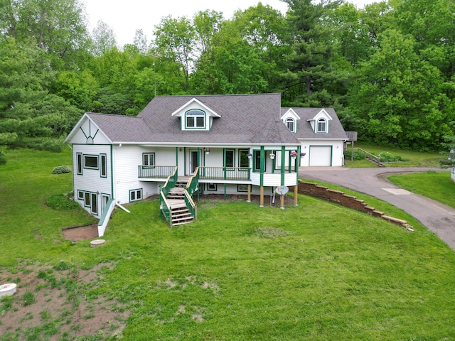 view of front of home with a porch, a garage, and a front lawn