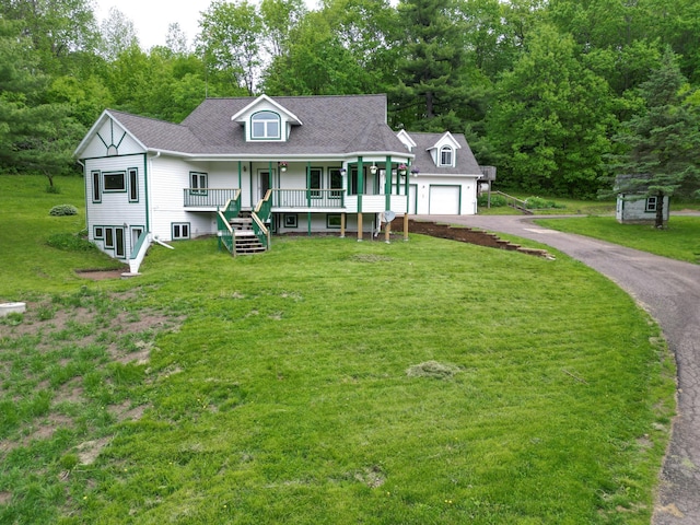 view of front facade featuring a garage, a porch, and a front lawn