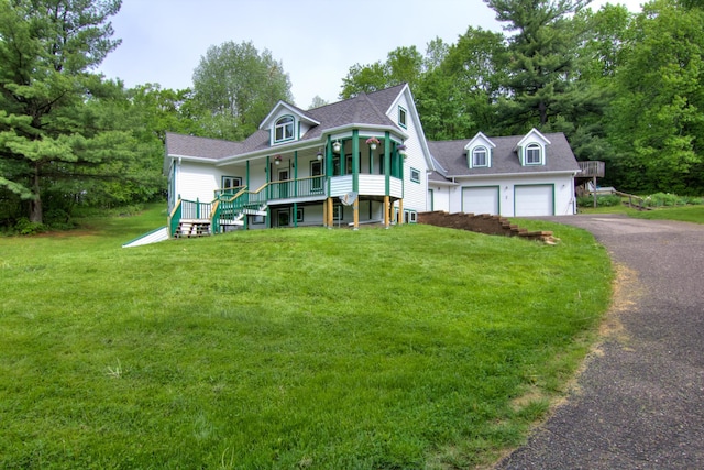 victorian home with covered porch, a garage, and a front yard