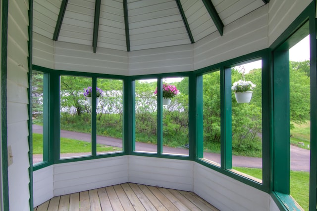 unfurnished sunroom with vaulted ceiling with beams, plenty of natural light, and wood ceiling