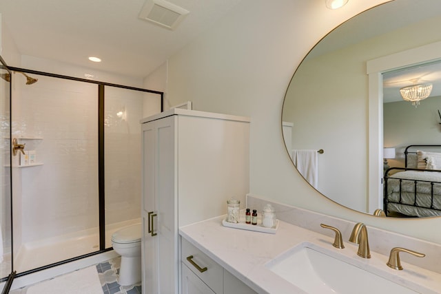 bathroom featuring a shower with shower door, tile flooring, toilet, and vanity with extensive cabinet space