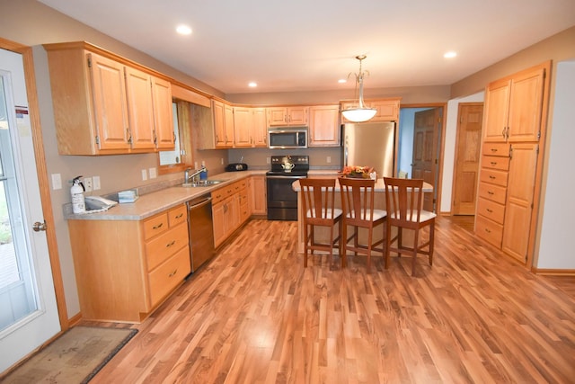 kitchen featuring sink, light brown cabinetry, light hardwood / wood-style floors, and appliances with stainless steel finishes