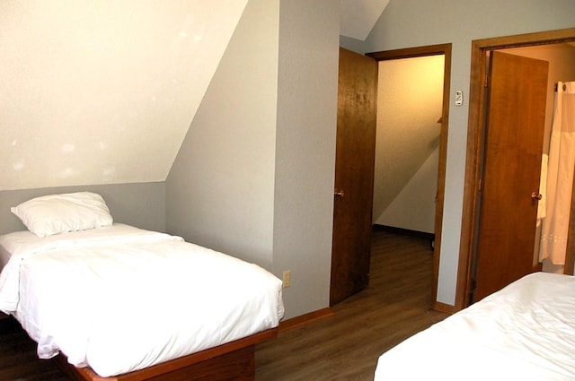 bedroom featuring dark wood-type flooring and lofted ceiling