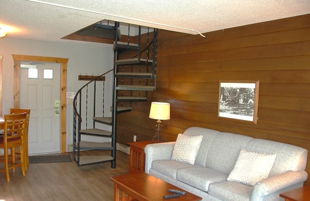 living room with wood walls, hardwood / wood-style flooring, and a textured ceiling