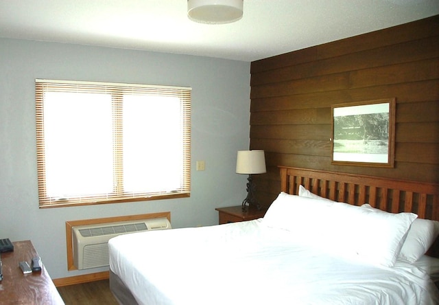 25124 Tame Fish Lake Rd Unit 550, Deerwood, MN 56444 - bedroom with an AC wall unit, wood finished floors, wooden walls, and multiple windows