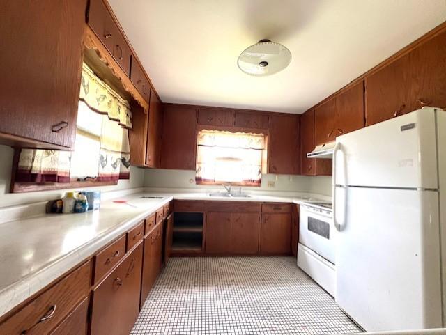 kitchen featuring sink, light tile flooring, and white appliances