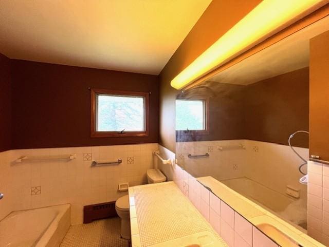 bathroom with a relaxing tiled bath, tile flooring, tile walls, and toilet