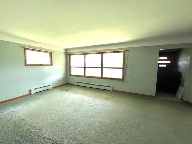 empty room featuring baseboard heating and carpet floors