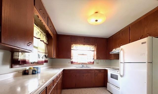 kitchen with sink, a healthy amount of sunlight, white appliances, and light tile floors