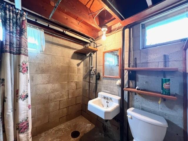 bathroom with sink, a shower with shower curtain, toilet, and tile walls