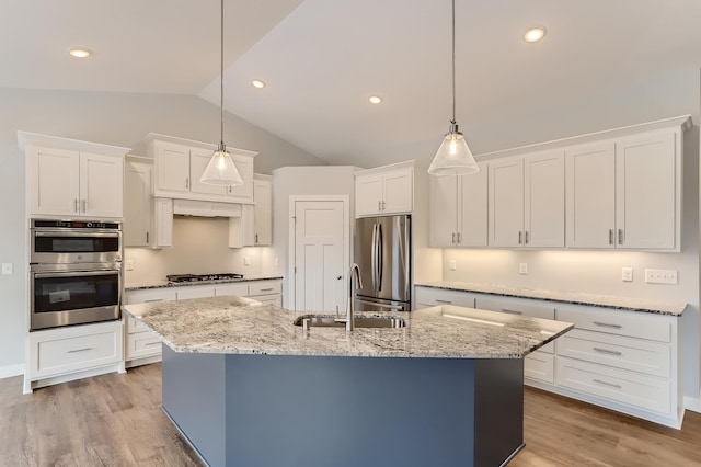 kitchen featuring sink, light hardwood / wood-style flooring, pendant lighting, vaulted ceiling, and appliances with stainless steel finishes