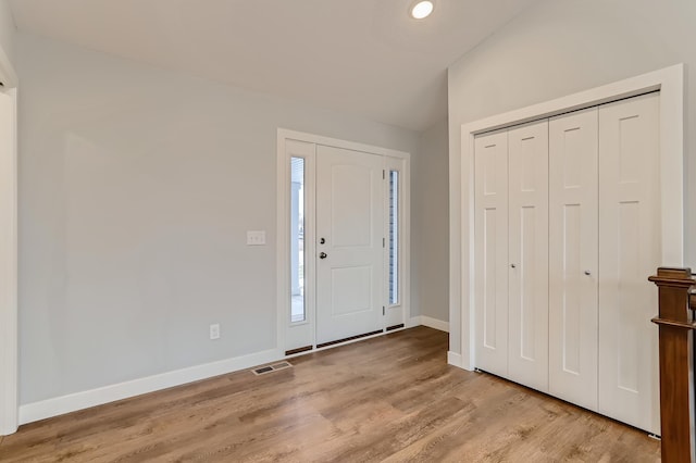 foyer featuring light hardwood / wood-style floors and vaulted ceiling