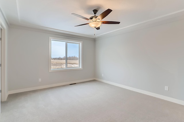 carpeted spare room with ceiling fan and crown molding