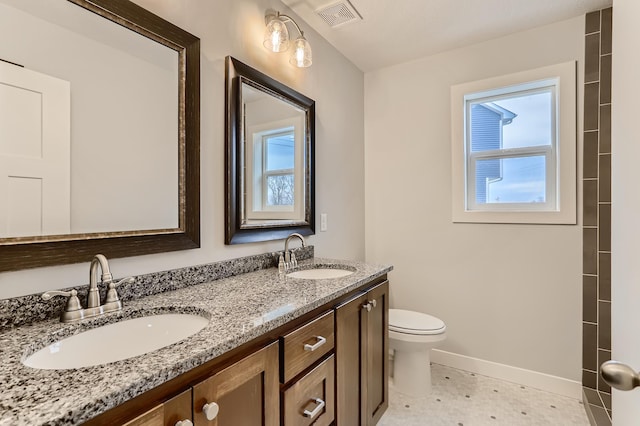 bathroom featuring tile patterned flooring, vanity, a healthy amount of sunlight, and toilet