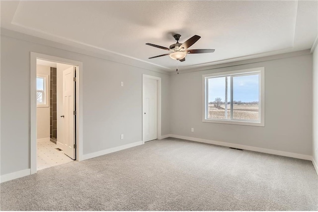 carpeted spare room featuring ceiling fan and a textured ceiling