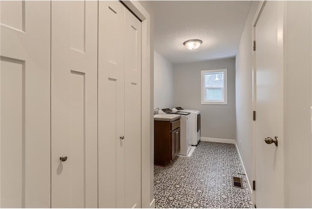 clothes washing area featuring cabinets and a textured ceiling