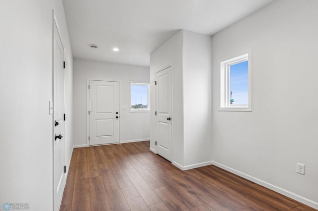 interior space featuring recessed lighting, baseboards, and dark wood finished floors