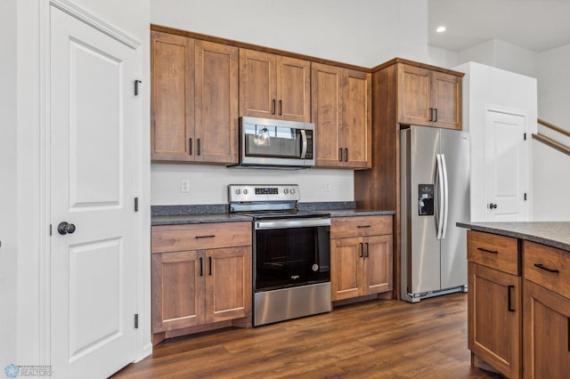 kitchen with brown cabinetry, dark wood-style flooring, recessed lighting, and stainless steel appliances