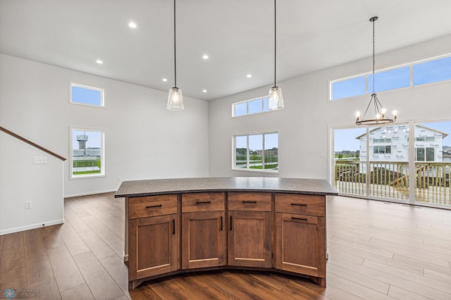 kitchen featuring plenty of natural light, dark wood-type flooring, a notable chandelier, and baseboards