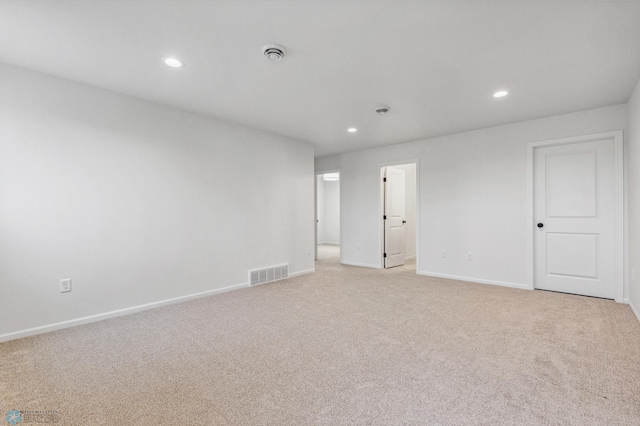 empty room featuring light carpet, recessed lighting, visible vents, and baseboards